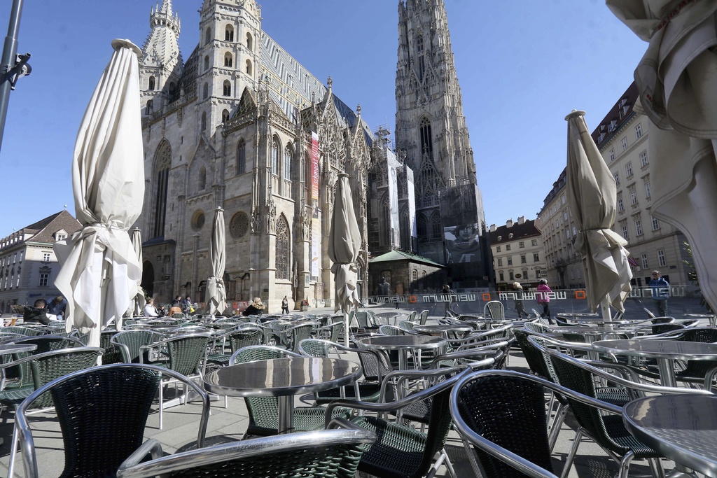 Guests are sitting in an outdoor restaurant in front of St. Stephen's Cathedral as part of the old town in Vienna, Austria, Sunday, March 15, 2020. The austrian government restricts freedom of movement. Bars and restaurants are also no longer allowed to open from Tuesday. Only for most people, the new coronavirus causes only mild or moderate symptoms, such as fever and cough. For some, especially older adults and people with existing health problems, it can cause more severe illness, including pneumonia. (AP Photo/Ronald Zak)