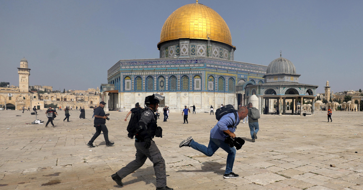 A member of Israeli police runs after a cameraman during clashes with Palestinians at the compound that houses Al-Aqsa Mosque, known to Muslims as Noble Sanctuary and to Jews as Temple Mount, in Jerusalem's Old City, May 10, 2021. REUTERS/Ammar Awad