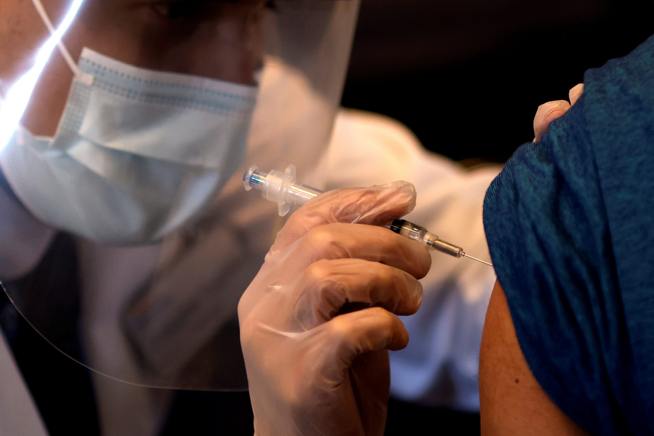 FILE PHOTO: A person receives a dose of the Johnson & Johnson coronavirus disease (COVID-19) vaccine during a visit of U.S. Vice President Kamala Harris to a vaccination center in Chinatown, in Chicago, Illinois, U.S., April 6, 2021. Picture taken April 6, 2021. REUTERS/Carlos Barria