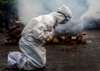 FILE - In this July 2, 2021, file photo, a woman breaks down as she prays before the cremation of a relative who died of COVID-19 in Gauhati, India. The global death toll from COVID-19 has eclipsed 4 million as the crisis increasingly becomes a race between the vaccine and the highly contagious delta variant. (AP Photo/Anupam Nath, File)