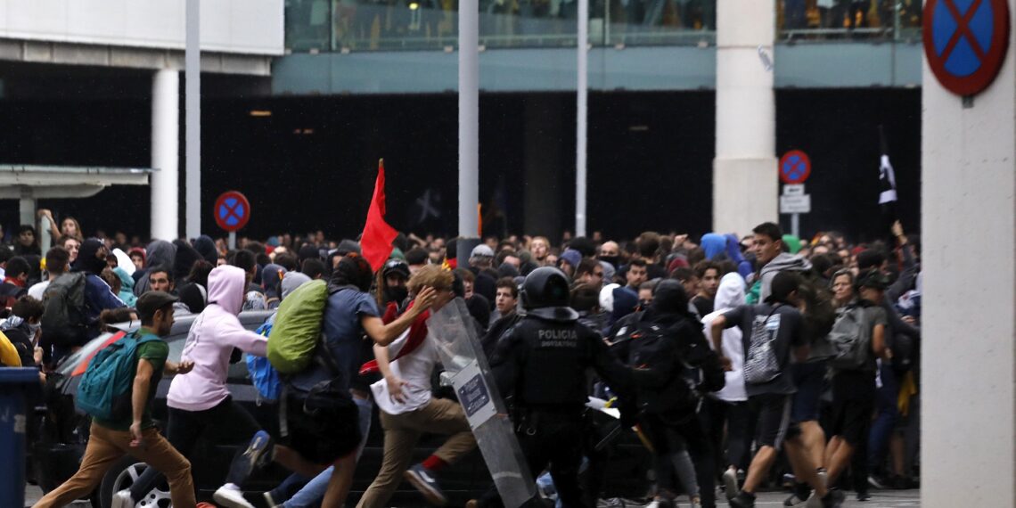 Riot policemen clash with protestors outside El Prat airport in Barcelona, Spain, Monday, Oct. 14, 2019. Riot police have charged at protesters outside Barcelona's airport after the Supreme Court sentenced 12 prominent Catalan separatists to lengthy prison terms for their roles in a 2017 push for the wealthy Spanish region's independence. (AP Photo/Emilio Morenatti) ORG XMIT: XAF127