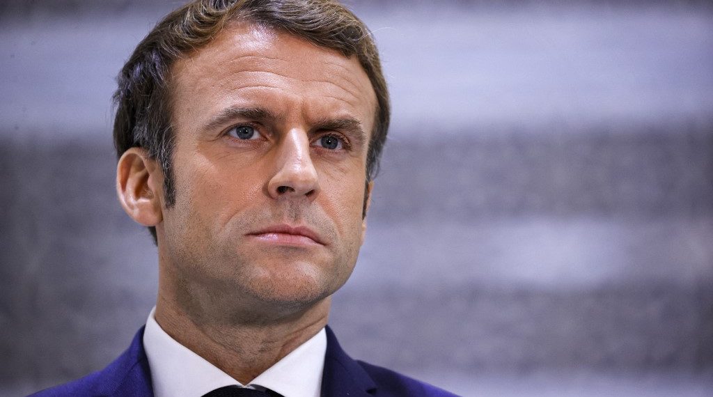 (FILES) This file photo taken on December 4, 2021 shows French President Emmanuel Macron briefing reporters at King Abdulaziz International Airport in Saudi Arabia's Red Sea coastal city of Jeddah. - President Emmanuel Macron on January 5, 2022 warned people in France not yet vaccinated against Covid-19 that he would cause them trouble by limiting access to key aspects of life in the country. (Photo by Thomas SAMSON / AFP)