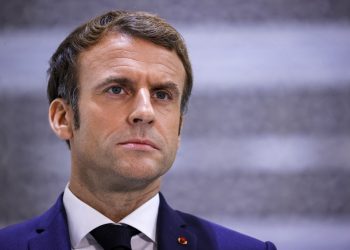 (FILES) This file photo taken on December 4, 2021 shows French President Emmanuel Macron briefing reporters at King Abdulaziz International Airport in Saudi Arabia's Red Sea coastal city of Jeddah. - President Emmanuel Macron on January 5, 2022 warned people in France not yet vaccinated against Covid-19 that he would cause them trouble by limiting access to key aspects of life in the country. (Photo by Thomas SAMSON / AFP)