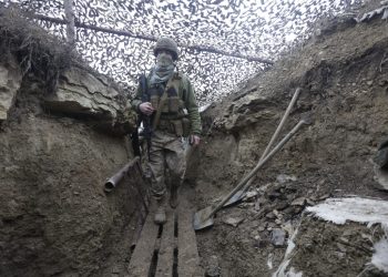 Ukrainian soldiers walks under a camouflage net in a trench on the line of separation from pro-Russian rebels near Debaltsevo, Donetsk region, Ukraine, Ukraine Friday, Dec 3, 2021. In this Friday, the Ukrainian defense minister warned that Russia could invade his country next month. Russia-West tensions escalated recently with Ukraine and its Western backers becoming increasingly concerned that a Russian troop buildup near the Ukrainian border could signal Moscow's intention to invade. (AP Photo/Andriy Dubchak)