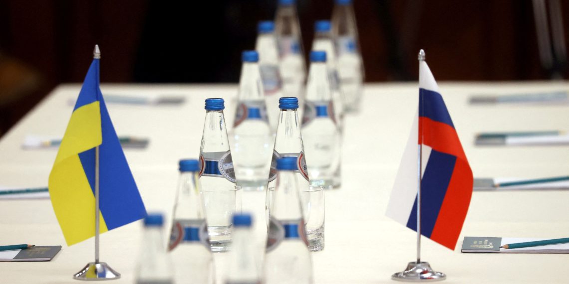 Russian and Ukrainian flags are seen on a table before the talks between officials of the two countries in the Gomel region, Belarus February 28, 2022.  Sergei Kholodilin/BelTA/Handout via REUTERS