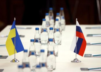 Russian and Ukrainian flags are seen on a table before the talks between officials of the two countries in the Gomel region, Belarus February 28, 2022.  Sergei Kholodilin/BelTA/Handout via REUTERS