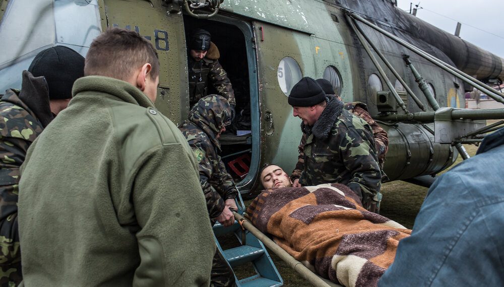 A wounded Ukrainian soldier is loaded onto a medevac helicopter on a sports field, which will take him and others to Dnipropetrovsk for treatment on February 8, 2015 in Artemivsk, Ukraine. Fighting between pro-Russia rebels and Ukrainian forces has dealt steady casualties to Ukrainian fighters and civilians.