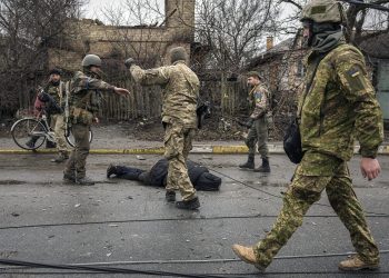 Ukrainian servicemen attach a cable to the body of a civilian while checking for booby traps in the formerly Russian-occupied Kyiv suburb of Bucha, Ukraine, Saturday, April 2, 2022. As Russian forces pull back from Ukraine's capital region, retreating troops are creating a "catastrophic" situation for civilians by leaving mines around homes, abandoned equipment and "even the bodies of those killed," President Volodymyr Zelenskyy warned Saturday.(AP Photo/Vadim Ghirda)