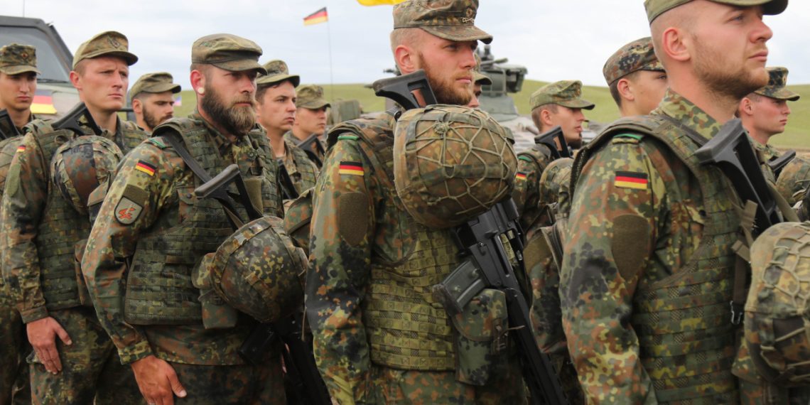 German army soldiers stand at attention for the Georgian natinal anthem during the closing ceremony for Noble Partner 18 at Vaziani Training Area, Georgia, Aug. 15, 2018. Noble Partner 18 was a cooperatively-led multinational training exercise in its fourth iteration which supported the training of Georgian Armed Forces' mechanized and Special Operation Forces, U.S. Regionally Aligned Forces, the U.S. Army and Air National Guard from the state of Georgia, and 11 other participating nations. (U.S. Army photo by Sgt. Kris Bonet)