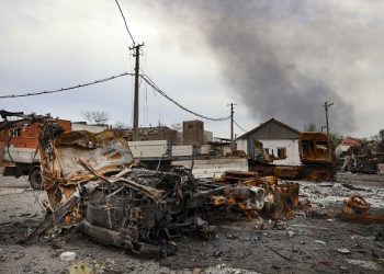 Burned vehicles are seen at the destroyed part of the Illich Iron & Steel Works Metallurgical Plant, as smoke rises from the Metallurgical Combine Azovstal during heavy fighting, in an area controlled by Russian-backed separatist forces in Mariupol, Ukraine, Monday, April 18, 2022. Mariupol, a strategic port on the Sea of Azov, has been besieged by Russian troops and forces from self-proclaimed separatist areas in eastern Ukraine for more than six weeks. (AP Photo/Alexei Alexandrov)