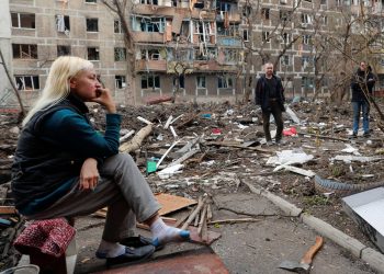 Local resident gather in a courtyard near a block of flats heavily damaged during Ukraine-Russia conflict in the southern port city of Mariupol, Ukraine April 18, 2022. REUTERS/Alexander Ermochenko