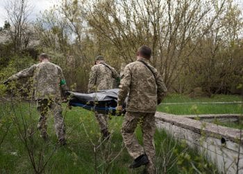 The body of a Russian soldier found in Mschchun is carried away.