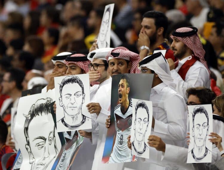 Soccer Football - FIFA World Cup Qatar 2022 - Group E - Spain v Germany - Al Bayt Stadium, Al Khor, Qatar - November 27, 2022 Fans hold up signs displaying former Germany player Mesut Ozil in the stands REUTERS/John Sibley - UP1EIBR1I2EJ9