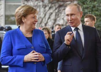 German Chancellor Angela Merkel greets Russian President Vladimir Putin (C) with Secretary-General of the United Nations (UN) Antonio Guterres upon his arrival to attend the Peace summit on Libya at the Chancellery in Berlin on January 19, 2020. - World leaders gather in Berlin on January 19, 2020 to make a fresh push for peace in Libya, in a desperate bid to stop the conflict-wracked nation from turning into a "second Syria". Chancellor Angela Merkel will be joined by the presidents of Russia, Turkey and France and other world leaders for talks held under the auspices of the United Nations. (Photo by John MACDOUGALL / AFP) / ALTERNATIVE CROP