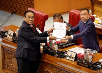 Bambang Wuryanto, head of the parliamentary commission overseeing the revision, passes the report of the new criminal code to Sufmi Dasco Ahmad, Deputy speaker of the House of Representatives, during a parliamentary plenary meeting in Jakarta, Indonesia, December 6, 2022. REUTERS/Willy Kurniawan