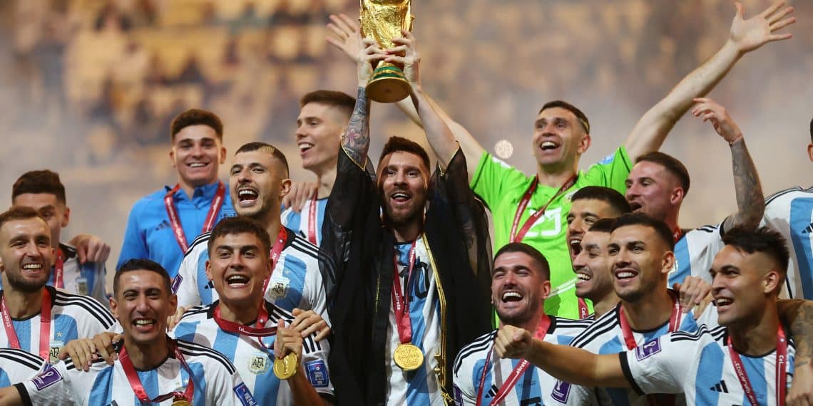 Soccer Football - FIFA World Cup Qatar 2022 - Final - Argentina v France - Lusail Stadium, Lusail, Qatar - December 18, 2022 Argentina's Lionel Messi lifts the World Cup trophy alongside teammates as they celebrate winning the World Cup  REUTERS/Carl Recine