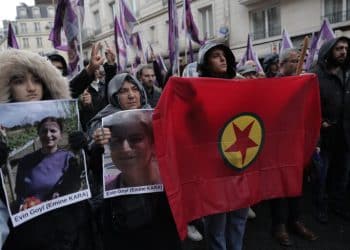 Kurdish activists hold flag and portraits as they march to honor three women Kurdish activists who were shot dead in 2013, Monday, Dec. 26, 2022 in Paris. A 69-year-old Frenchman is facing preliminary charges of racially motivated murder, attempted murder and weapons violations over last Friday's shooting, prosecutors said. The shooting shocked and infuriated the Kurdish community in France. ( AP Photo/Lewis Joly)