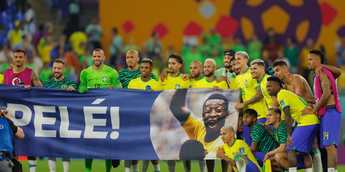 Brazil players stand behind a banner honouring Brazilian football legend Pele after they won the Qatar 2022 World Cup round of 16 football match between Brazil and South Korea at Stadium 974 in Doha on December 5, 2022. (Photo by Odd ANDERSEN / AFP)