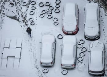 A pedestrian passes by cars covered in snow, in Kyiv, Ukraine November 30, 2022. REUTERS/Gleb Garanich