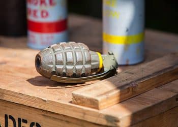 WWII era Hand Grenade sitting on top of a wooden crate - stock image