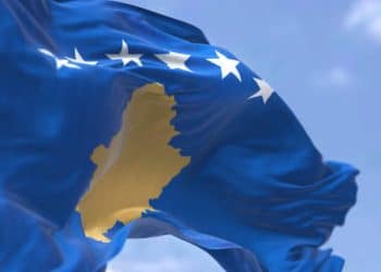 Detail of the national flag of Kosovo waving in the wind on a clear day. Kosovo is a partially recognized state in Southeast Europe. Selective focus.