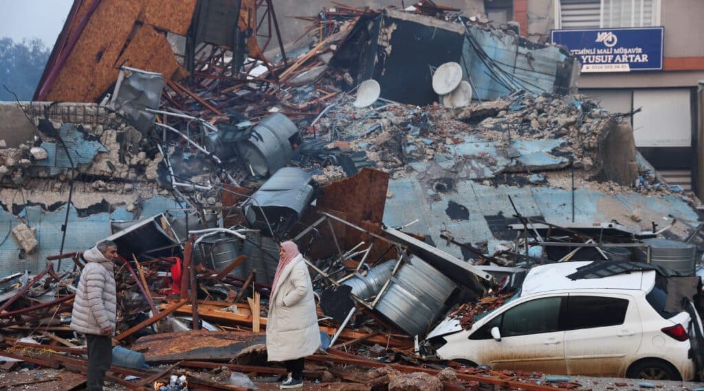 People look at rubble and damage following an earthquake in Hatay, Turkey, February 7, 2023. REUTERS/Umit Bektas