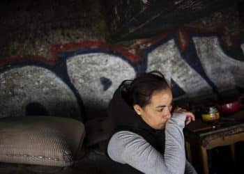 Jessica, a homeless heroin addict, wipes away tears as she describes how she tested positive for HIV after being raped last year in this spot under the bridge where she lives  in the Kensington neighborhood of Philadelphia, Pennsylvania, on April 14, 2017. - In North Philadelphia, railroad gulch as it is known, is ground zero in Philadelphia's opioid epidemic. "80 percent of us want to get out," said Jessica, before outlining the numerous ways she has tried to get treatment for her addiction. In one case, she said, there weren't any available beds. In another, a treatment provider required a positive drug test before delivering aid, meaning if she hadn't used recently she'd be denied. Instead of getting treatment, she spends her nights trying to keep warm on a mattress under a bridge, the very spot where she was raped and infected with HIV.  People come from throughout the city, and some as far away as the Midwest, for heroin that is remarkably cheap and pure at the largest heroin market on the East coast. (Photo by DOMINICK REUTER / AFP)