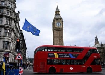 An EU flag, flown by anti-Conservative and anti-Brexit activists, flaps in the air in front of the Elizabeth Tower, commonly known by the name of the bell inside the tower's clock, "Big Ben", and the Palace of Westminster, Houses of Parliament in central London on March 1, 2023 as a bus drives past. (Photo by Justin TALLIS / AFP)